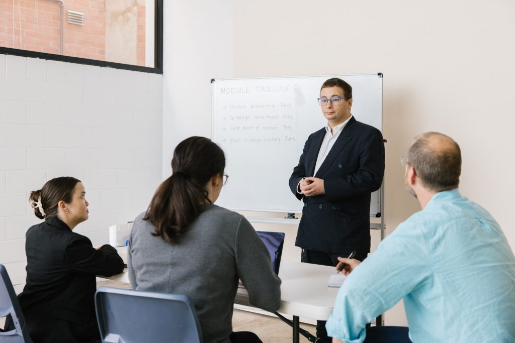 A man in a business suit presents to a group of people