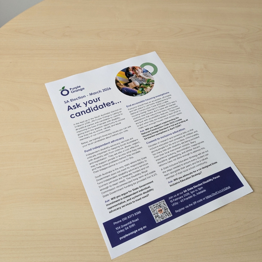 Printed copy of the A4 Ask your candidates flyer on a wooden tabletop.